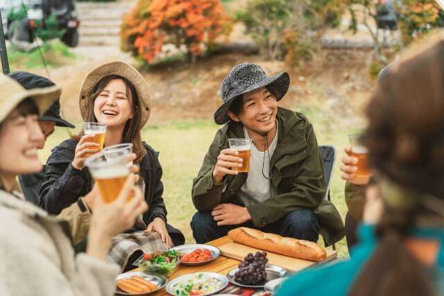 キャンプ場で食事をしている仲間